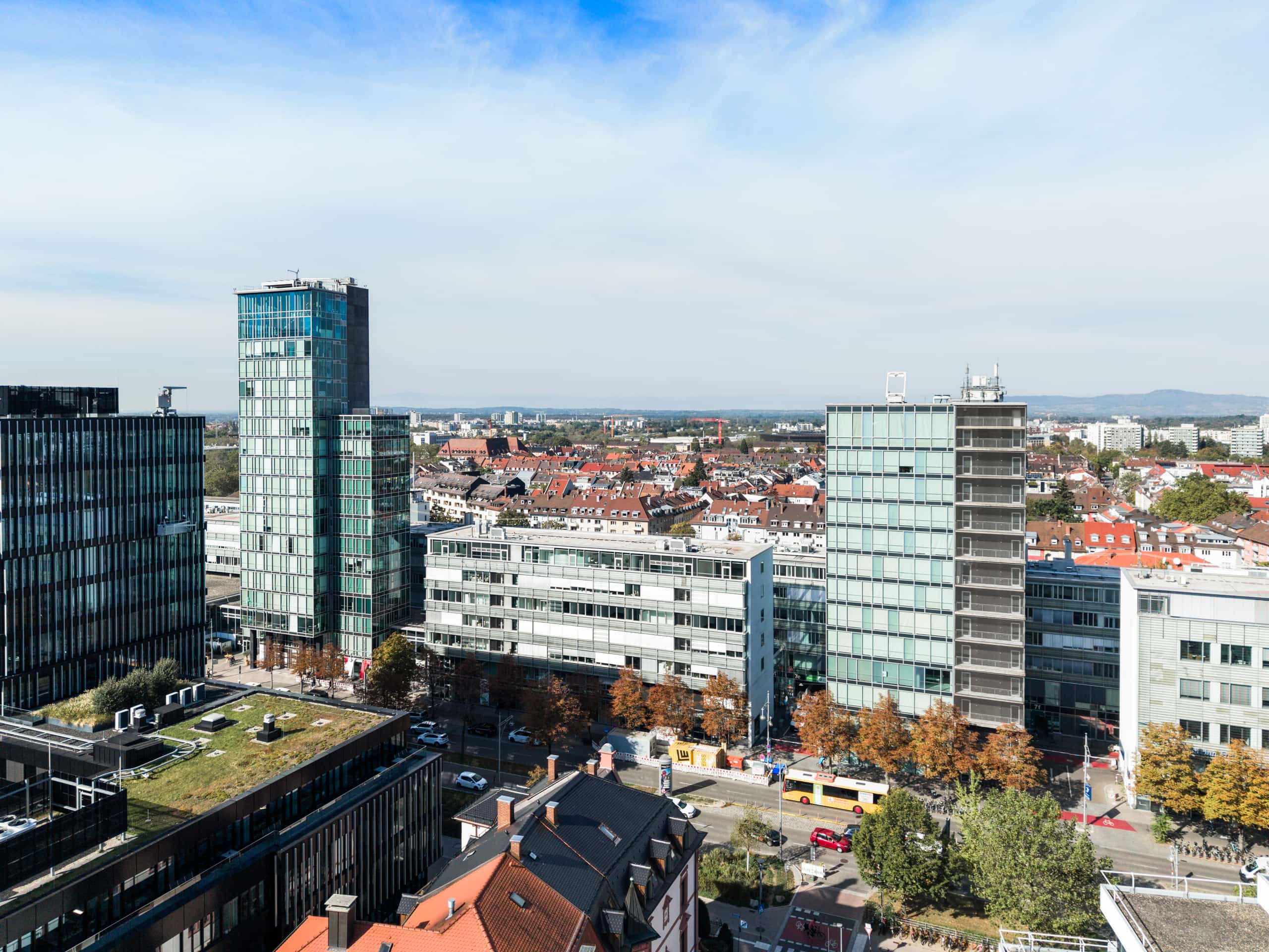 Luftaufnahme der Bahnhofszeile Freiburg mit Bürotürmen am Hauptbahnhof und Blick über die Stadt