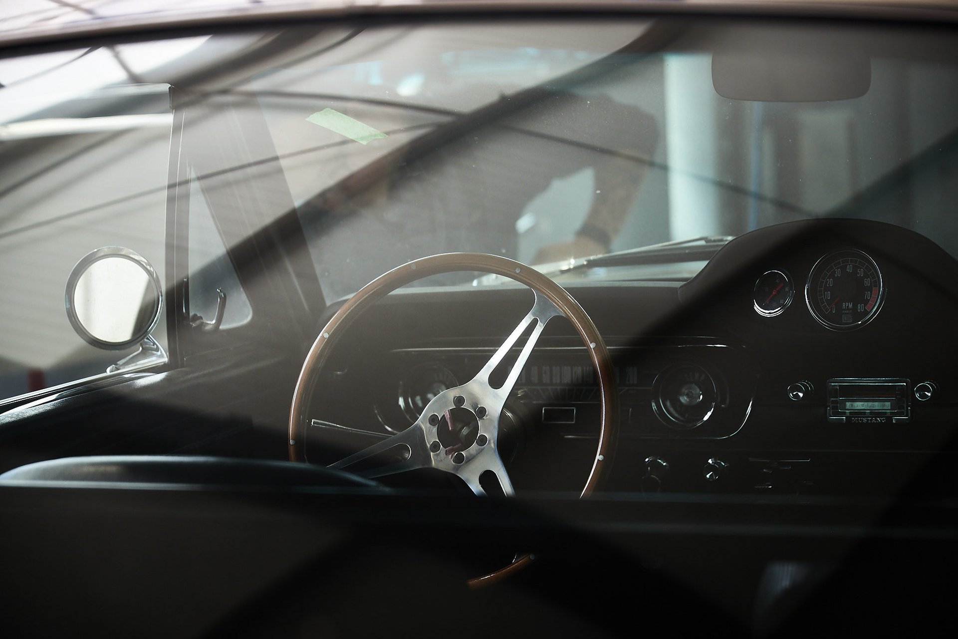 Blick durch die Windschutzscheibe auf das Lenkrad und Armaturenbrett eines Oldtimers.