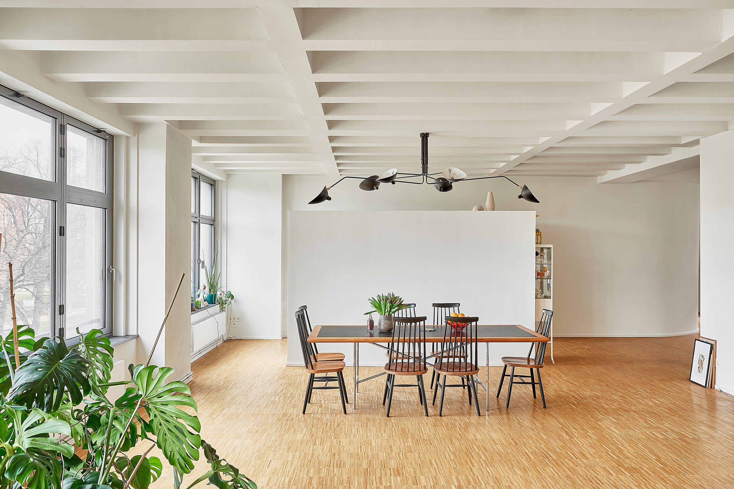 Bruno Taut Haus Berlin, für die Dahler Company: Ein heller Raum mit Holzboden, einem Esstisch mit Stühlen, großen Fenstern und einer Decke mit sichtbaren Balken